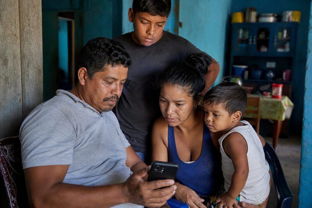 Familia venezolana utiliza un teléfono inteligente para recibir dinero del exterior
