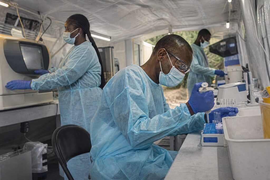 Personal sanitario procesa muestras en un laboratorio móvil durante la respuesta al brote de ébola.
