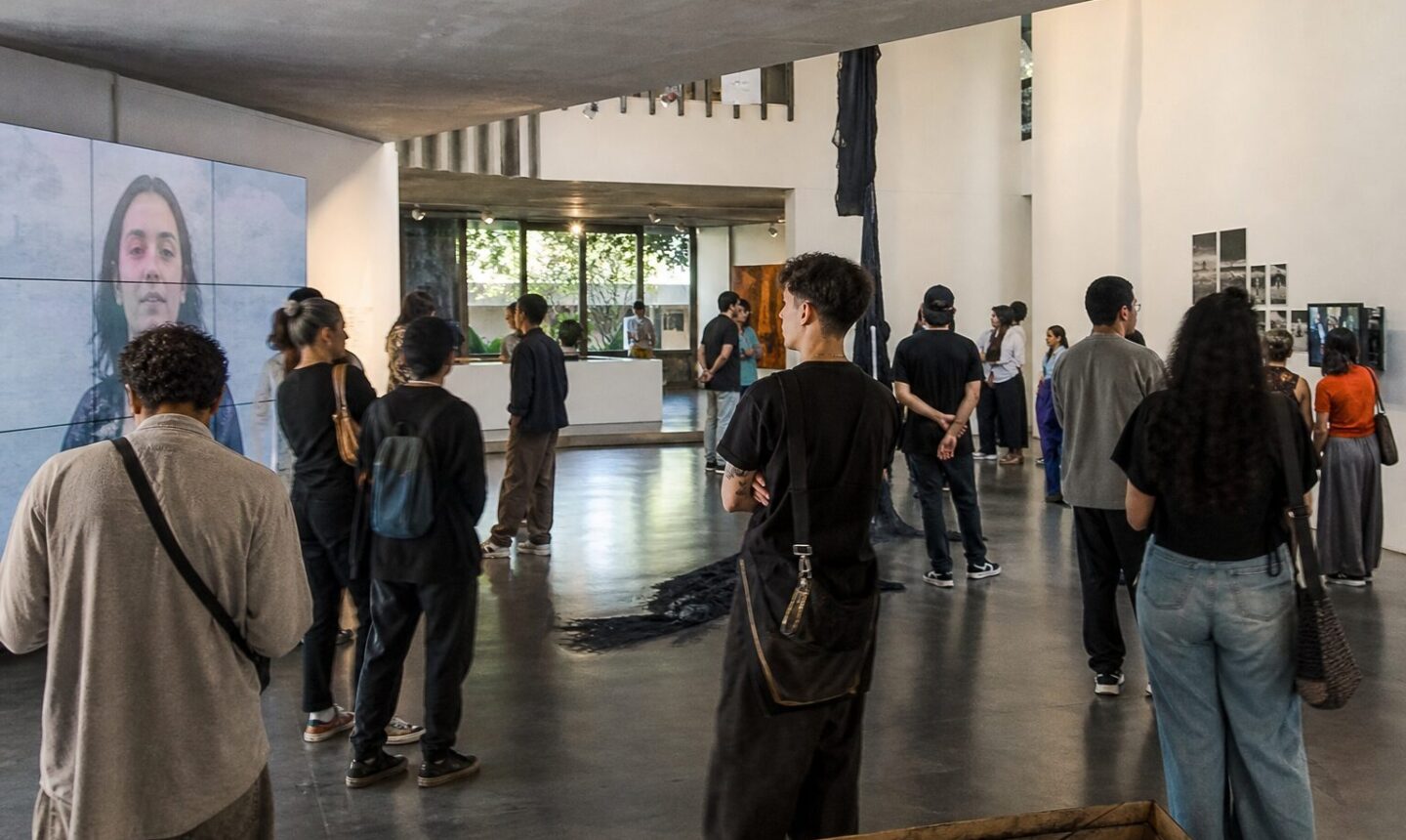 Visitantes observan obras de artistas jóvenes venezolanos en una sala de exposición contemporánea en Caracas.