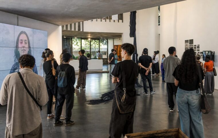 Visitantes observan obras de artistas jóvenes venezolanos en una sala de exposición contemporánea en Caracas.